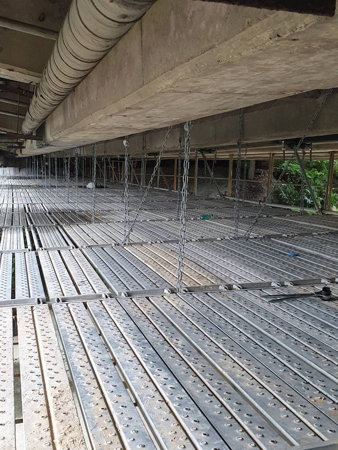 柏凱鷹架工程於三峽拱橋側邊架設之懸吊架工作走道，展示安全護網與高強度吊鏈固定技術。