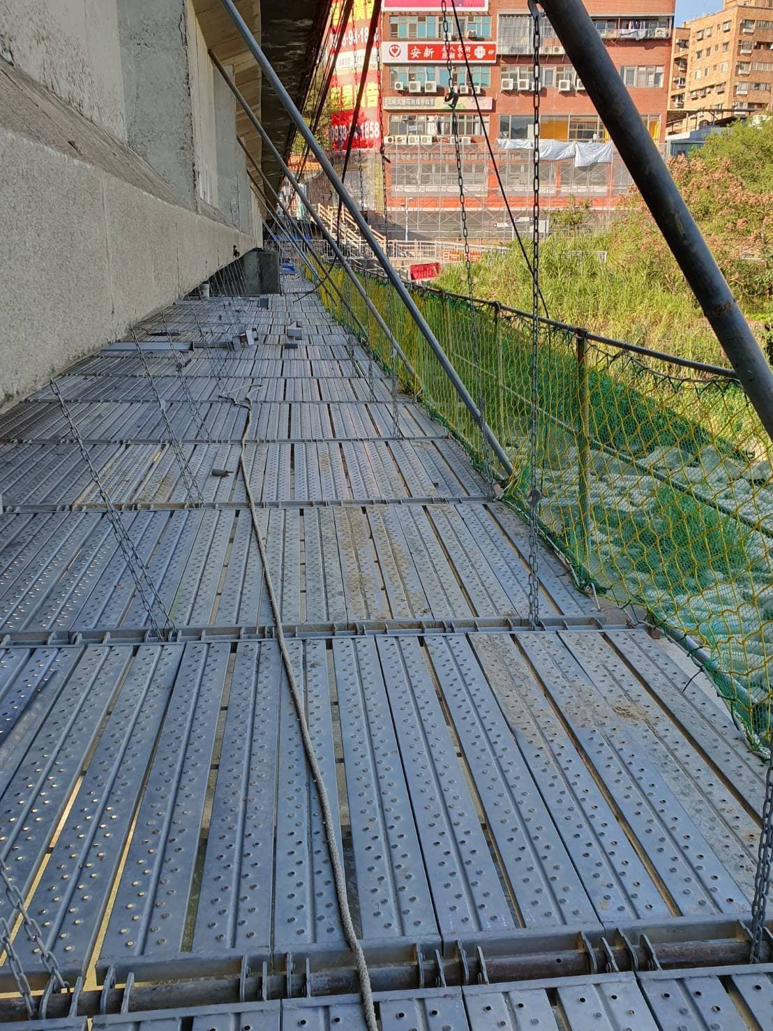 三峽拱橋底部的大面積懸吊式施工平台，柏凱鷹架利用鋼索與系統踏板，在三峽河上方建構穩固的修復平面。