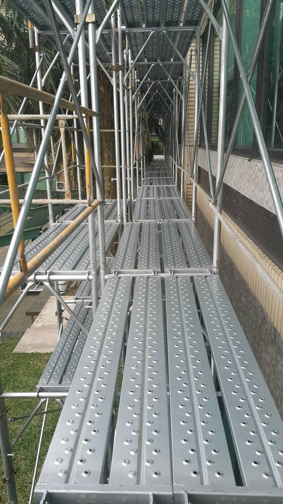 桃園長庚紀念醫院大型外牆維修與拉皮鷹架工程搭配吊車作業現場照